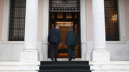 Papademos (rechts) betritt mit seinem Vorgänger den Sitz des Ministerpräsidenten.