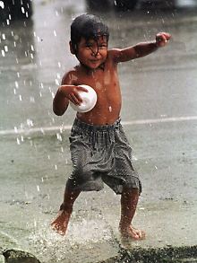 Ein kleiner Junge in Manila erfreut sich am erfrischenden Regen.