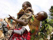Eine junge Frau sucht in einem Flüchtlingslager bei Limuru (Nigeria) im Abfall nach Schuhen. (Archivbild von 2008)