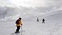 Skifahrer und Snowboarder fahren auf der Zugspitze bei Grainau die Piste hinab.