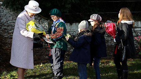 Kinder überreichen der Monarchin am 1. Weihnachtstag Blumen.