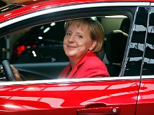 Trotz freundlich dreinblickender Kanzlerin: Der Gegenwind wird auch für Opel schärfer.