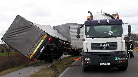 Die Feuerwehr sichert in Würselen bei Aachen einen Lastwagen, der vom böigen Wind von der Straße geweht wurde.
