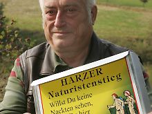 Ludwig mit einem Schild des neuen Nackt-Wanderweges.