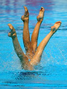 Beine von Synchronschwimmerinnen. 