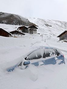 Ein zugeschneites Auto in Haggen in Tirol. 