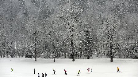 Langläufer und Spaziergänger spazieren in Oberstdorf durch den Schnee.