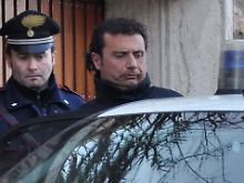 Kapitän Grosseto wird von einem Polizeibeamten ins Auto begleitet.
