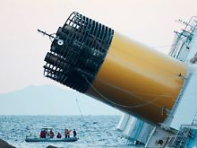 Möglicherweise befinden sich noch weitere Passagiere im Rumpf der  "Costa Concordia". Taucher suchen das Wrack ab.