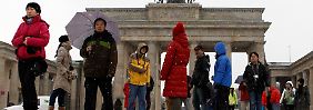 Auch bei Kälte und Schnee ein Anziehungspunkt: Touristen vor dem Brandenburger Tor in Berlin.