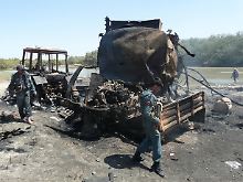 Afghanische Sicherheitskräfte untersuchen die explodierten Tankwagen.