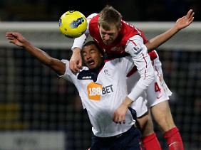 Augen zu und durch: Arsenals  Per Mertesacker und Boltons David N'Gog.