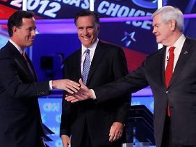 Seltene Einmütigkeit: So lange Santorum (li.) und Gingrich (re.) im Rennen bleiben, freut sich Romney.