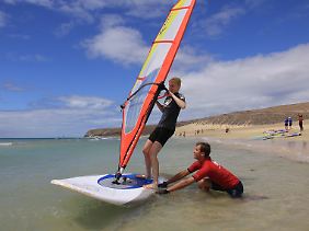 Surflehrer Enrico bringt Carolin aus Ulm bei, das Gleichgewicht auf dem Brett zu halten.