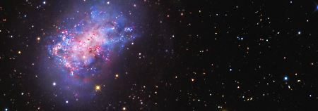 Die Zwerggalaxie NGC 4449 (oben links) und die noch kleinere Galaxie, die dabei ist, von ihr verschlungen zu werden (unten rechts).
