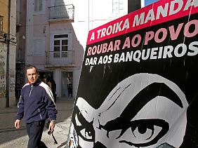 Geballter Protest gegen die Troika in Athen. Auf dem Plakat steht: Die Troika verlangt, "Nehmt es von den Menschen und gebt es den Bankern".