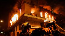 Feuerwehrleute vor einem brennenden Gebäude in Athen.
