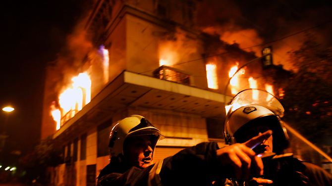 Feuerwehrleute vor einem brennenden Gebäude in Athen.