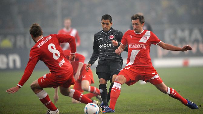 Düsseldorfs Sascha Dum (l.) und Adam Bodzek (r.) kämpfen mit Frankfurts Karim Matmour um den Ball. 