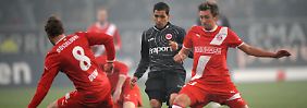 Düsseldorfs Sascha Dum (l.) und Adam Bodzek (r.) kämpfen mit Frankfurts Karim Matmour um den Ball. 