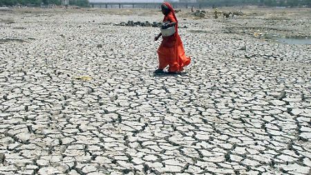Um Wasser zu holen, überquert eine Inderin in Ahmedabad das ausgetrocknete Flußbett des Sabarmati.