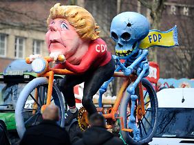 Motivwagen beim Karneval in Düsseldorf: Merkel mit einer toten FDP auf dem Tandem.