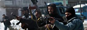Afghanische Polizisten feuern auf protestierende Landsleute.