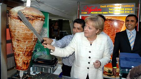 Bundeskanzlerin Angela Merkel schneidet in einem Döner-Laden in Berlin ein Stück Fleisch von einem Döner-Spieß (Archivfoto vom 25.08.2008).