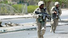 US-Soldaten  bei einem Feuergefecht in Sadr City in Bagdad eine Straße.