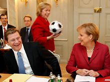 Staatsministerin Böhmer läuft zum Beginn einer Kabinettsitzung mit einem Ball hinter Kanzlerin Merkel und Außenminister Westerwelle entlang.