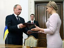 Ein Geben und Nehmen: Wladimir Putin und Julia Timoschenko tauschen die unterzeichneten Dokumente aus. 
