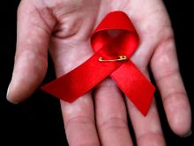 Die rote Aids-Schleife ist ein Symbol der Solidarität mit HIV-Infizierten und AIDS-Kranken. 