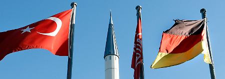  Eine deutsche und eine türkische Flagge wehen vor dem Minarett einer Moschee im Stadtteil Hassel in Gelsenkirchen.