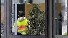 Ein Polizeibeamter steht in Stuttgart in einem Büro der LBBW.