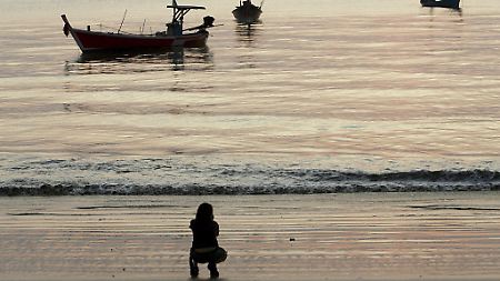 Ein Tourist genießt den Anblick: Fischerboote in Khao Lak.