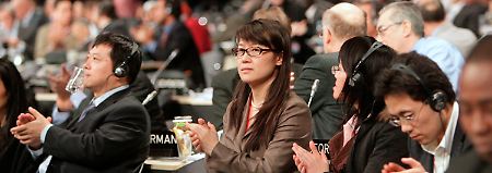 Die chinesische Delegation klatscht - China ist mit der windelweichen Vereinbarung zufrieden.