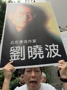 Ein Demonstrant mit einem Bild Liu Xiaobos.
