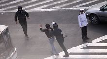 Ein Polizist führt einen Demonstranten ab.