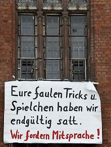 Ein Transparent der ehemaligen Häftlinge vor einem Fenster des früheren  Stasi-Gefängnisses in der Erfurter Andreasstraße.