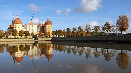 Das Jagdschlosses Moritzburg bei Dresden spiegelt sich im Wasser.