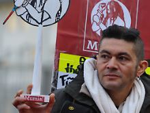 Mit einer symbolischen Todesspritze in der Hand demonstriert ein Gegner der Todesstrafe am 6. November 2009 vor dem US-Generalkonsulat in Frankfurt am Main für Mumia Abu-Jamal.