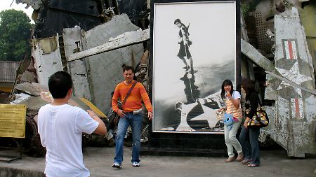 Hanoi der Widersprüche: Obwohl junge Vietnamesen längst aufs Kapital statt auf den Kommunismus setzen, gehört ein Erinnerungsfoto an dem abgeschossenen US-B52-Bomber am Armeemuseum zu jedem Hauptstadtbesuch.
