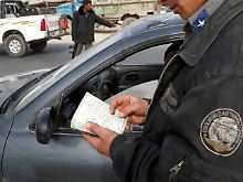 Kabul: Ein afghanischer Polizist prüft die Papiere eines Autofahrers.
