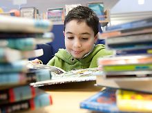 Ein Junge liest in der Stadtbibliothek in Melle, Niedersachsen.