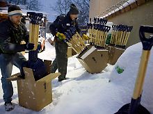 In Washington packen zwei Mitarbeiter eines Baumarkts eine neue Ladung Schneeschippen aus.