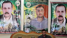Der Palästinenser Fayeq el-Mabhuh sitzt vor den Porträts seines Bruders und Hamas-Kommandeurs Mahmud el-Mabhuh, (l und r).