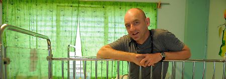 Peter Tinnemann am Krankenbett eines kleinen beinamputierten haitianischen Mädchens. 