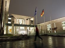 Vor dem hell erleuchteten Bundeskanzleramt in Berlin.