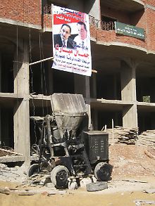 Ein Plakat mit Präsident Mubarak und sein Sohn Gamal haben Bauherren an einem Rohbau in Nasr-City aufgehängt, nachdem die ägyptische Regierung den angedrohten Abriss eines Neubaus dort aufgehalten hatte. 