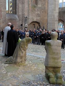 Trauernde Kölner stehen vor dem Denkmal "Die trauernden Eltern" in der Kirche Alt Sankt Alban.